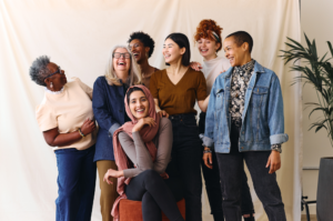 A diverse group of women laugh as they pose for a photograph