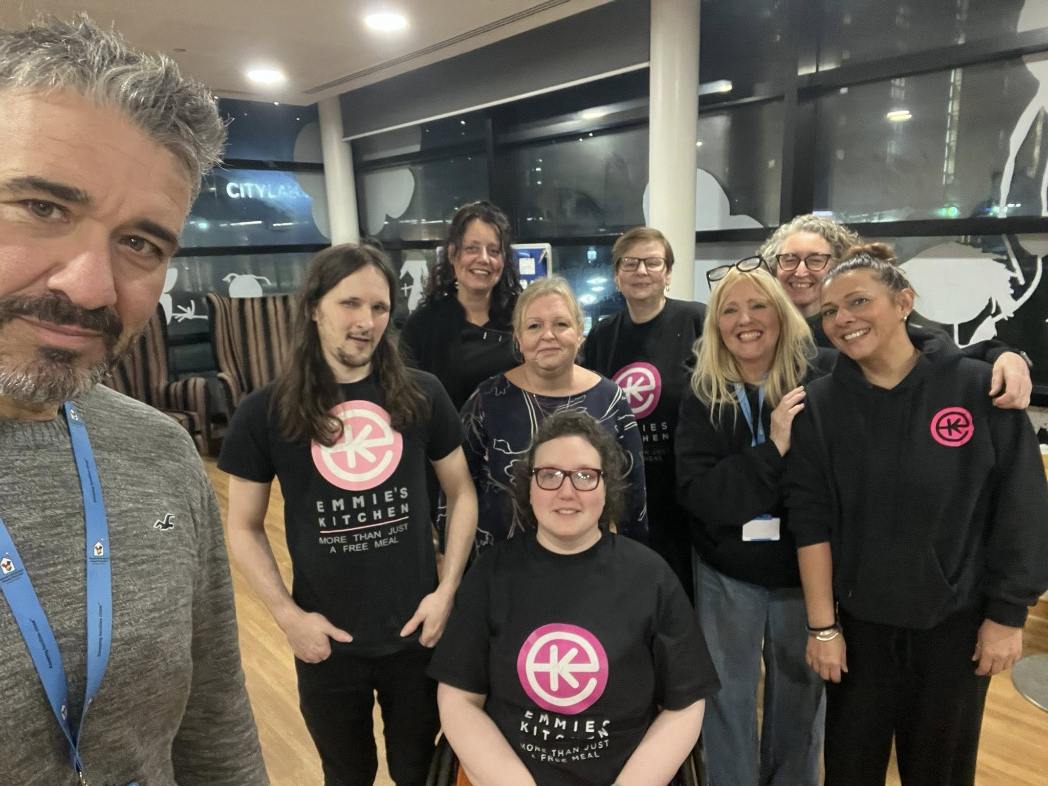 Emmies Kitchen Team Emmis Kitchen Team provide support to parents at Manchester children's hospital. All 9 people smiling for a team photo wearing branded hoodies
