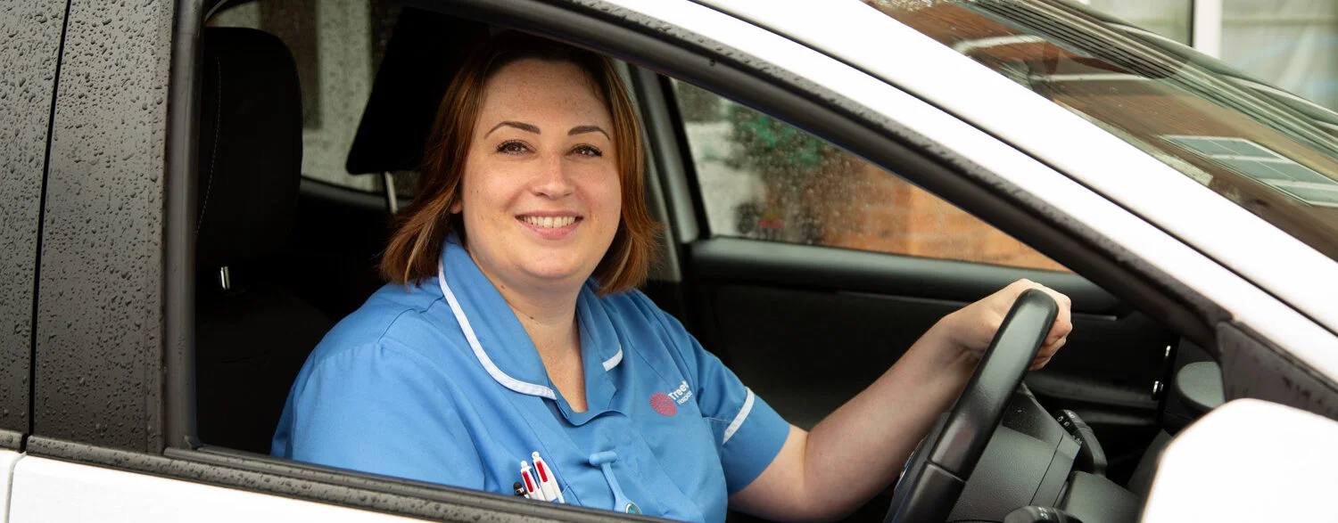 smiling-nurse-in-a-car-e1728294185232 Treetops Hospice nurse driving to visit a patient receiving palliative care in Derbyshire