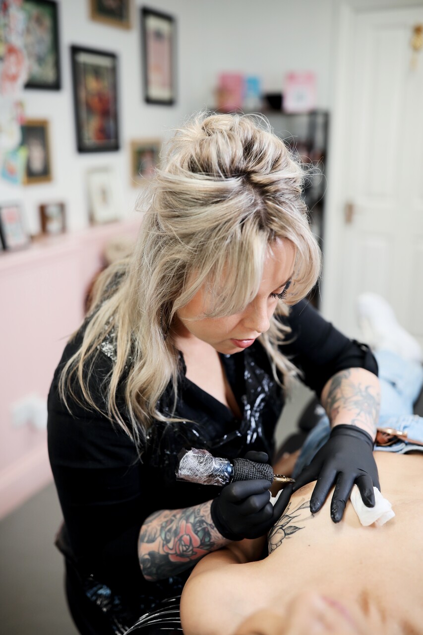 Tattoo artist working with a client Tattoo artist specialising in mastectomy tattoos working with a client